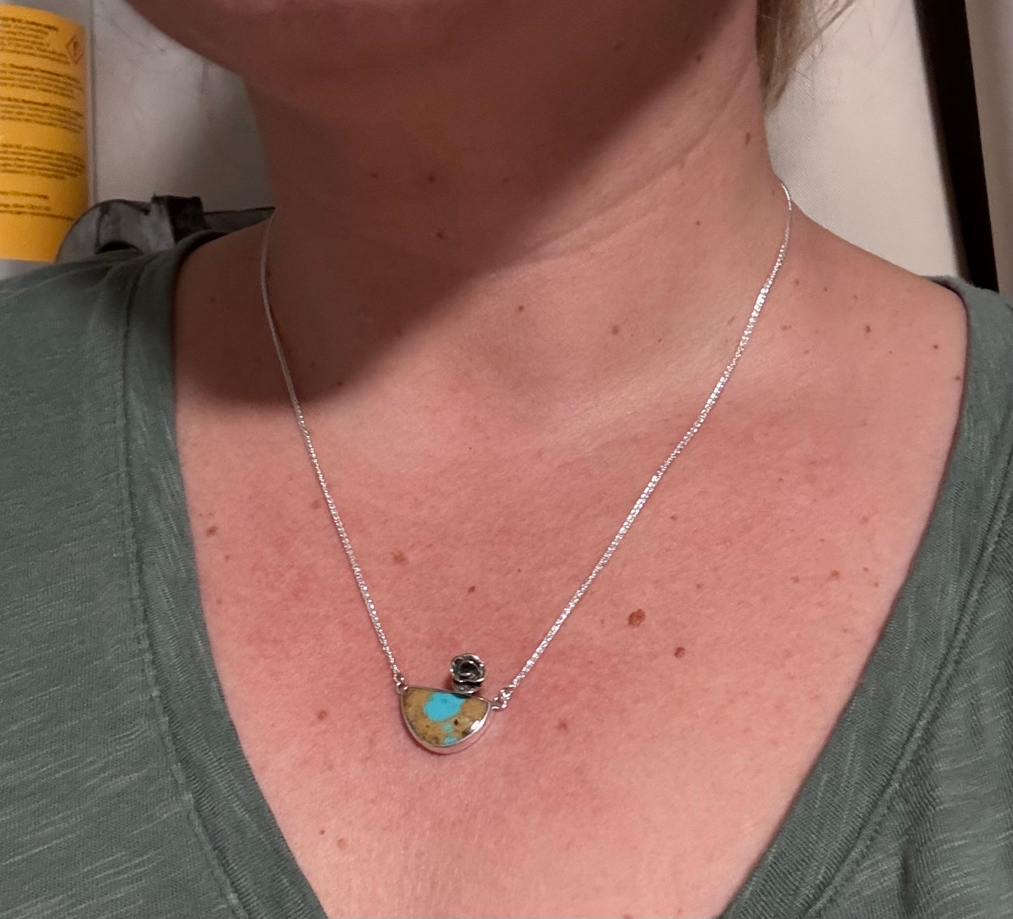 Necklace with a pendant worn by a person, close-up view.