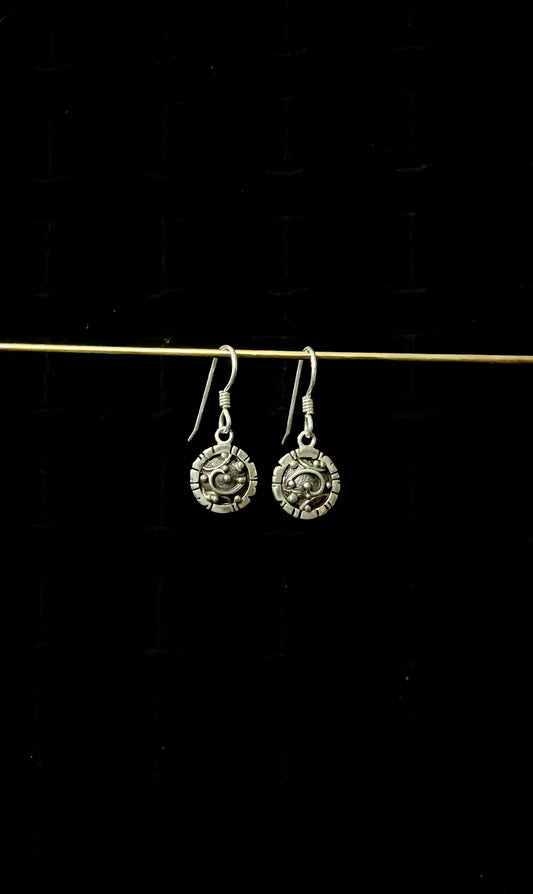 A pair of silver round lightweight drop earrings displayed against a black background.