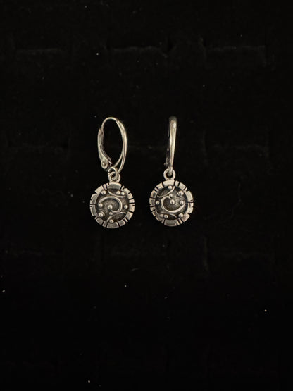 Pair of silver earrings on a black background