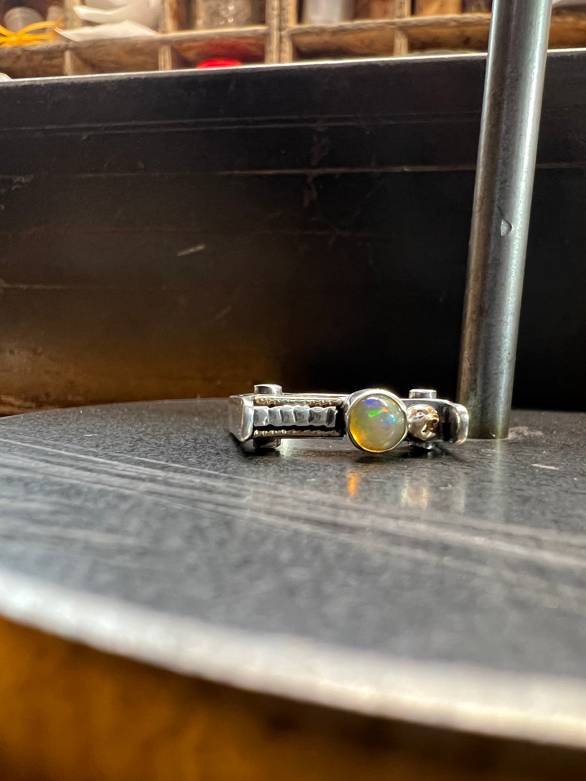 Sterling Silver Bar Ring with Opal and Yellow Gold Accents – handcrafted sterling silver bar-style band ring with bezel-set white opal and yellow gold accent details, black background