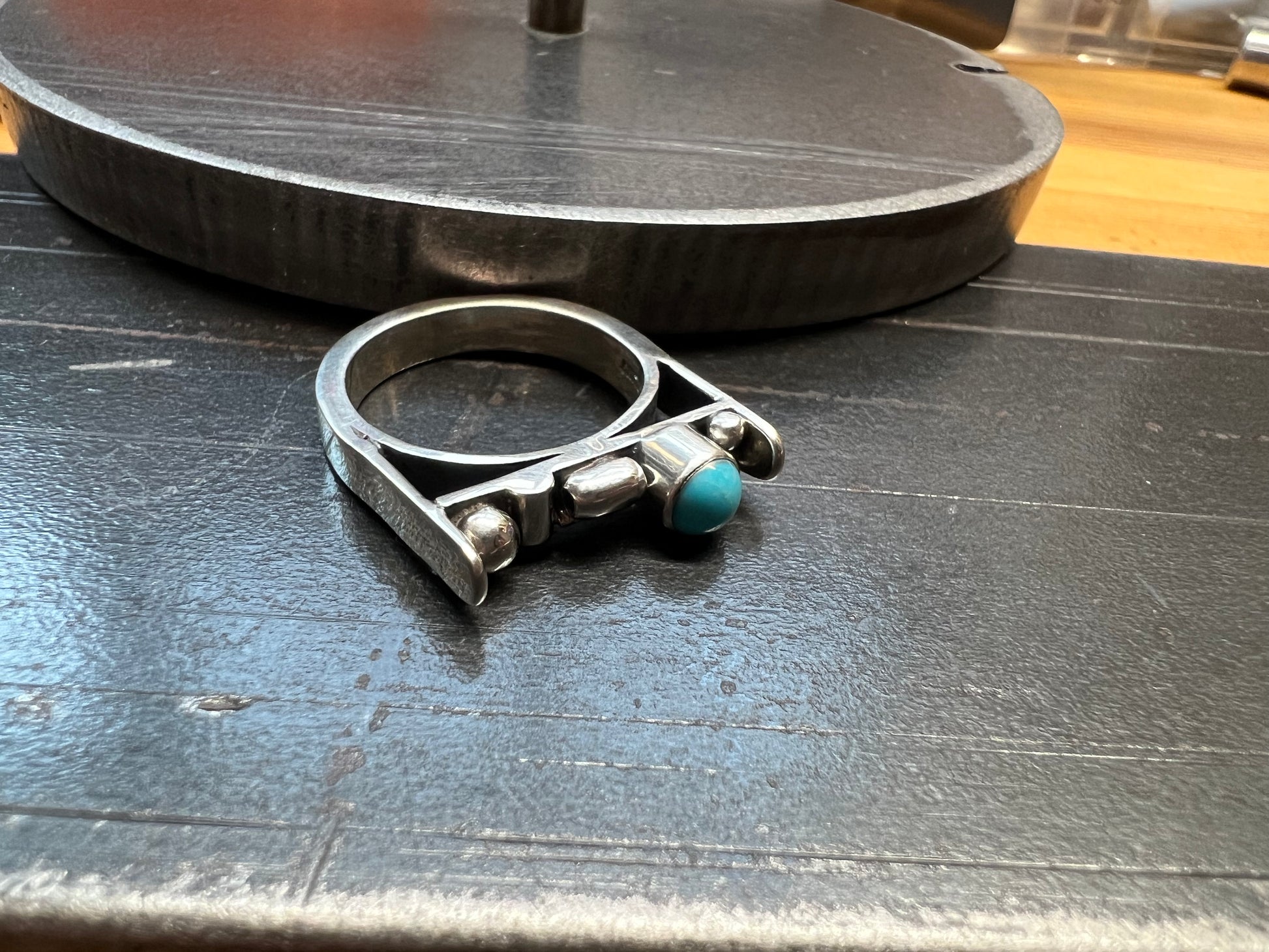 Sterling Silver Bar Ring with Turquoise and Rose Gold Accents – close-up of sterling silver bar ring showing bezel-set turquoise stone with rose gold accent wire detail, black background