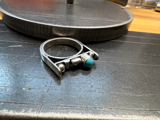 Sterling Silver Bar Ring with Turquoise and Rose Gold Accents – close-up of sterling silver bar ring showing bezel-set turquoise stone with rose gold accent wire detail, black background