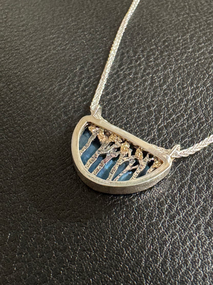 Silver necklace with a half-circle pendant on a dark textured surface