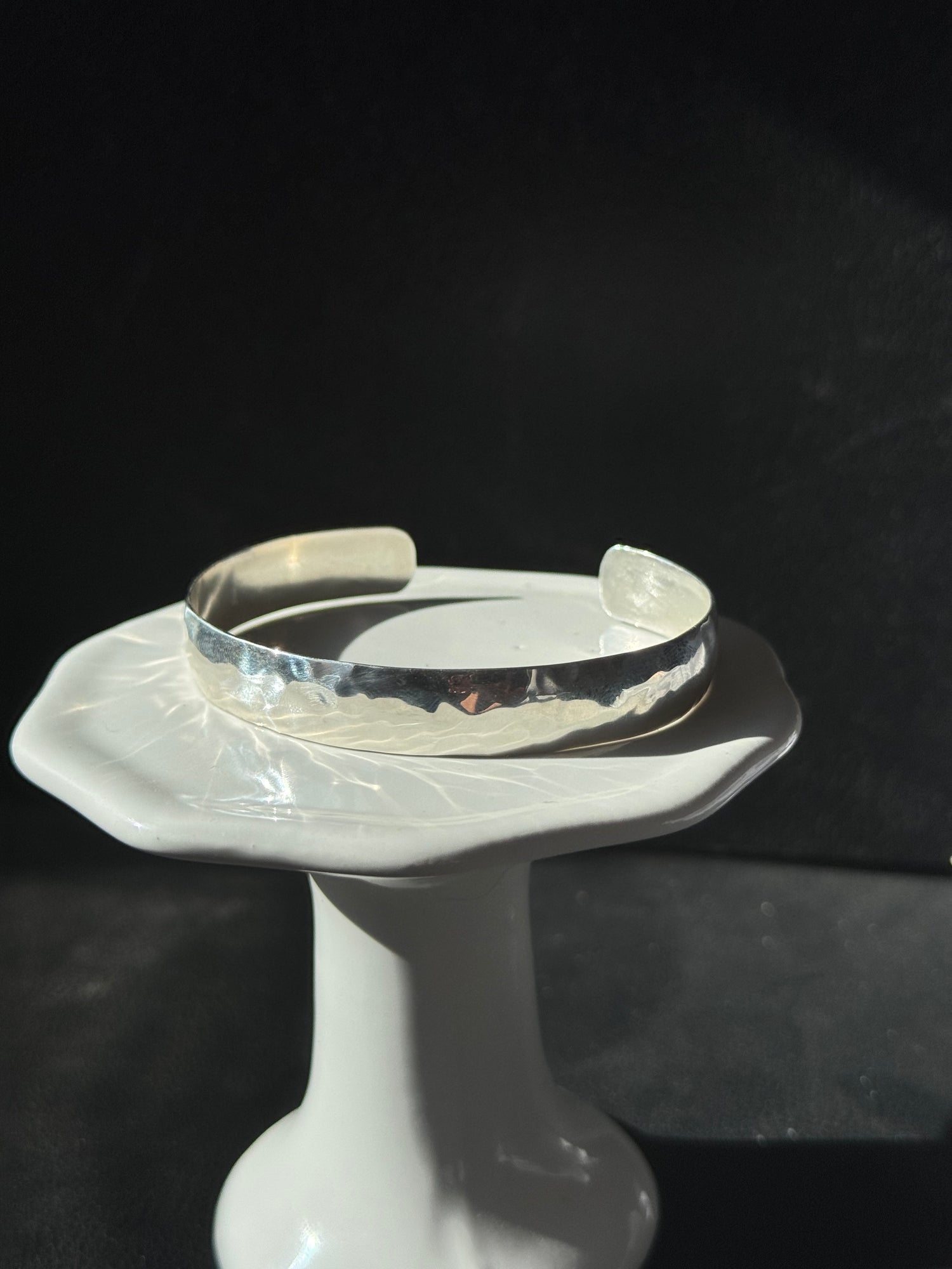 Clear plastic bracelet on a mannequin arm against a dark background