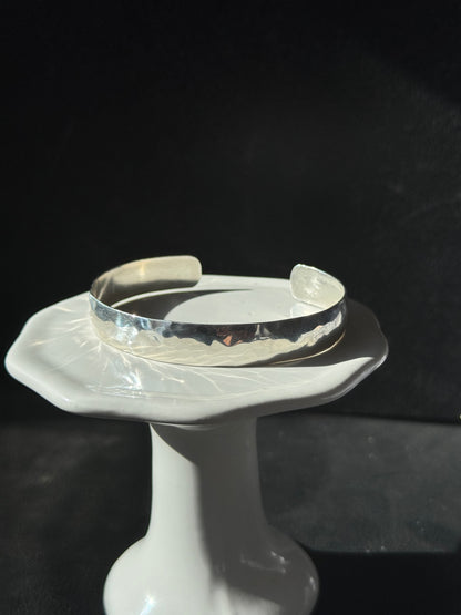 Clear plastic bracelet on a mannequin arm against a dark background