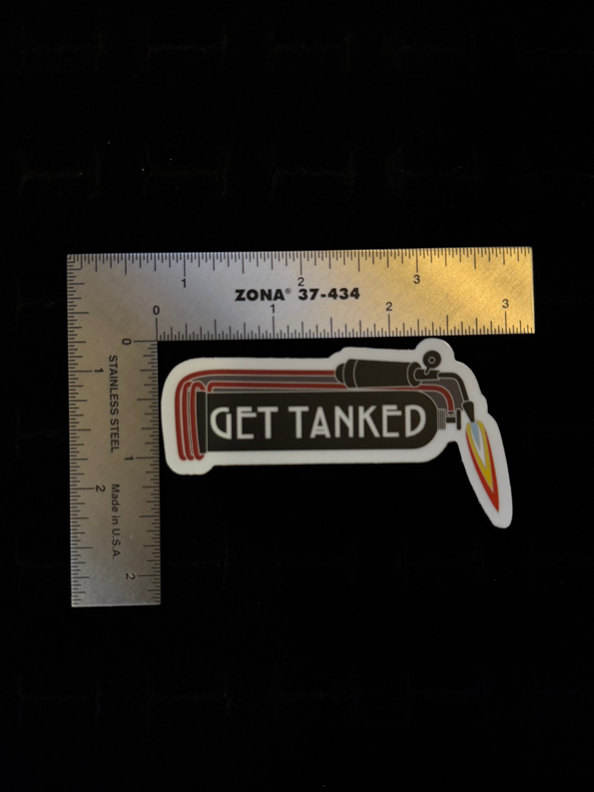 Get Tanked sticker – lifestyle shot of white die-cut sticker from The Tiny Smithery applied to surface