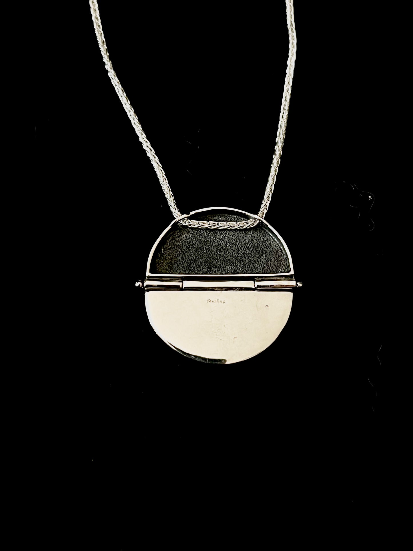 Sterling Silver Hinged Sweater Pendant Necklace – lifestyle shot of handcrafted sterling silver sweater-texture disc pendant necklace worn on neck, black background