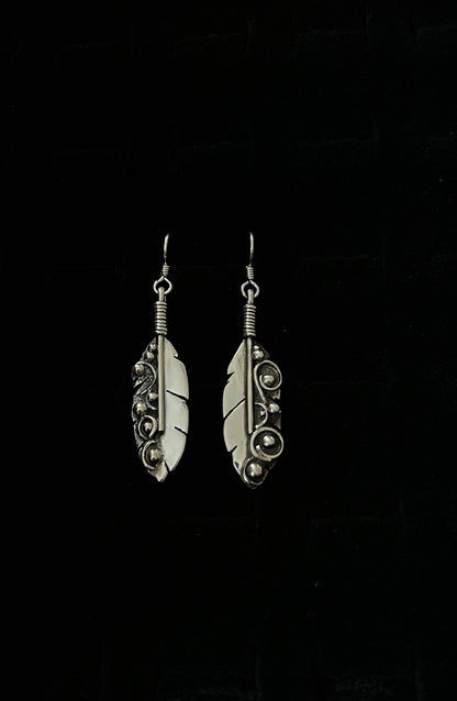 Long Feather Earrings – close-up of sterling silver long oxidized feather drop earrings showing quill and barb texture detail, black background