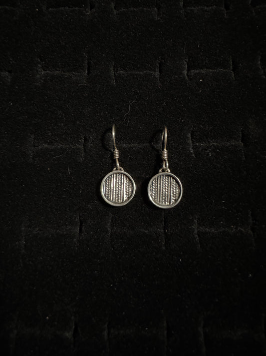Pair of silver badminton racket earrings on a dark textured background