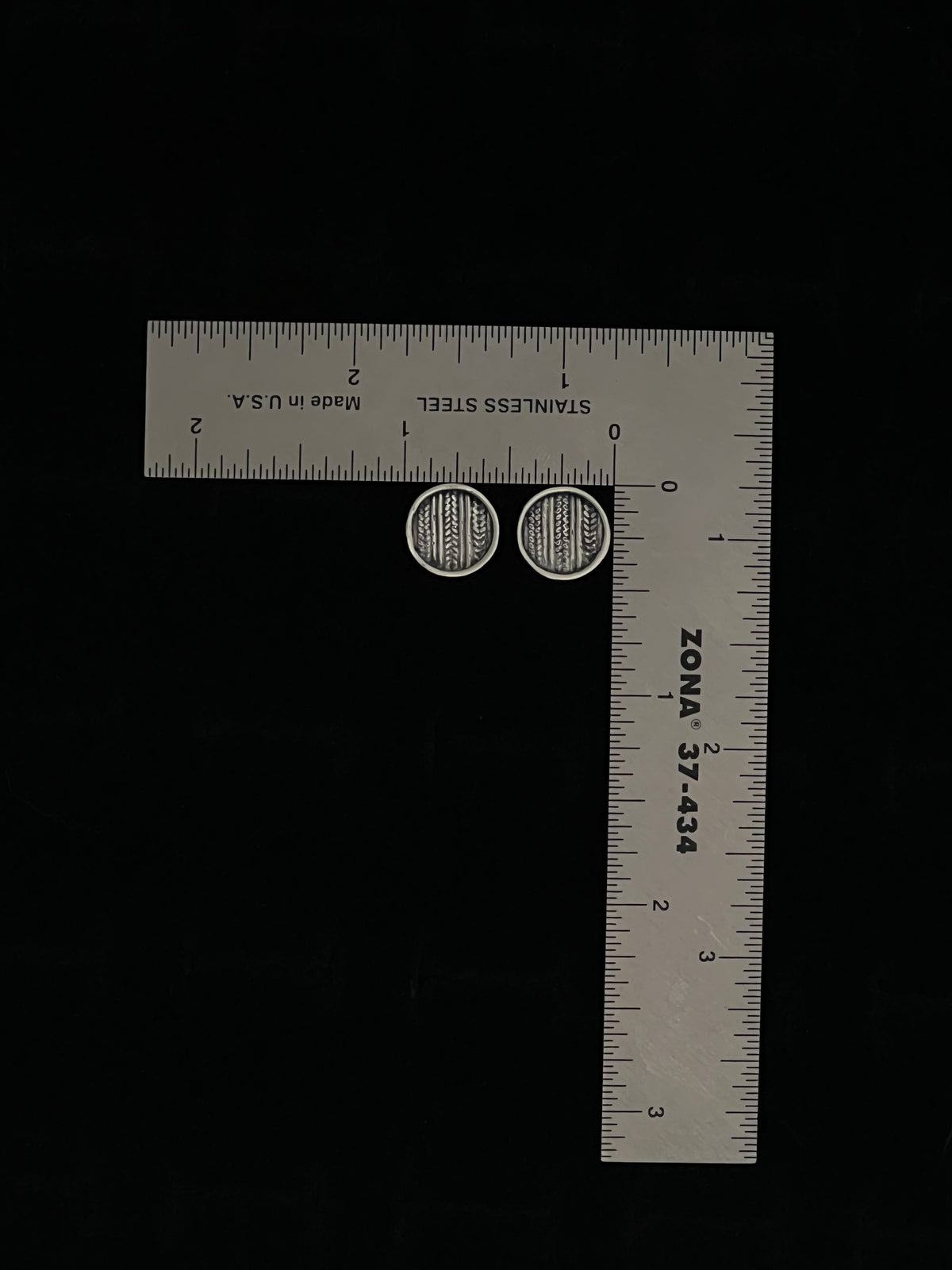 Medium Sweater Post Earrings – size reference showing sterling silver knit-texture disc stud earrings approximately half inch wide next to ruler, black background