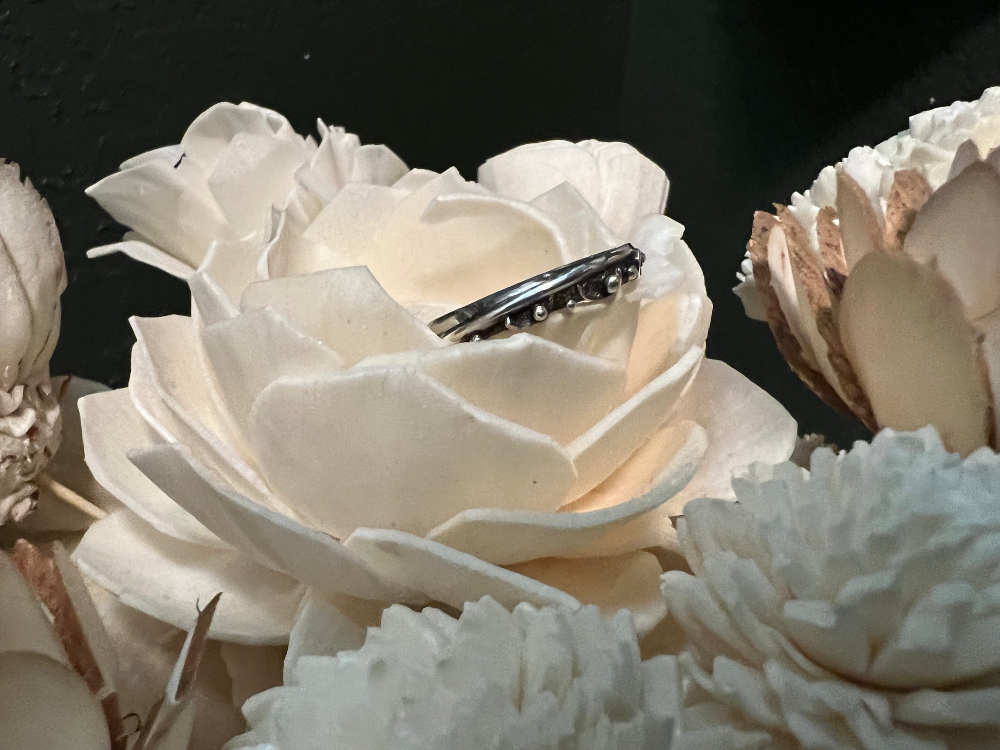 Narrow Feather Ring – close-up of sterling silver narrow feather-texture band ring showing oxidized detail, black background