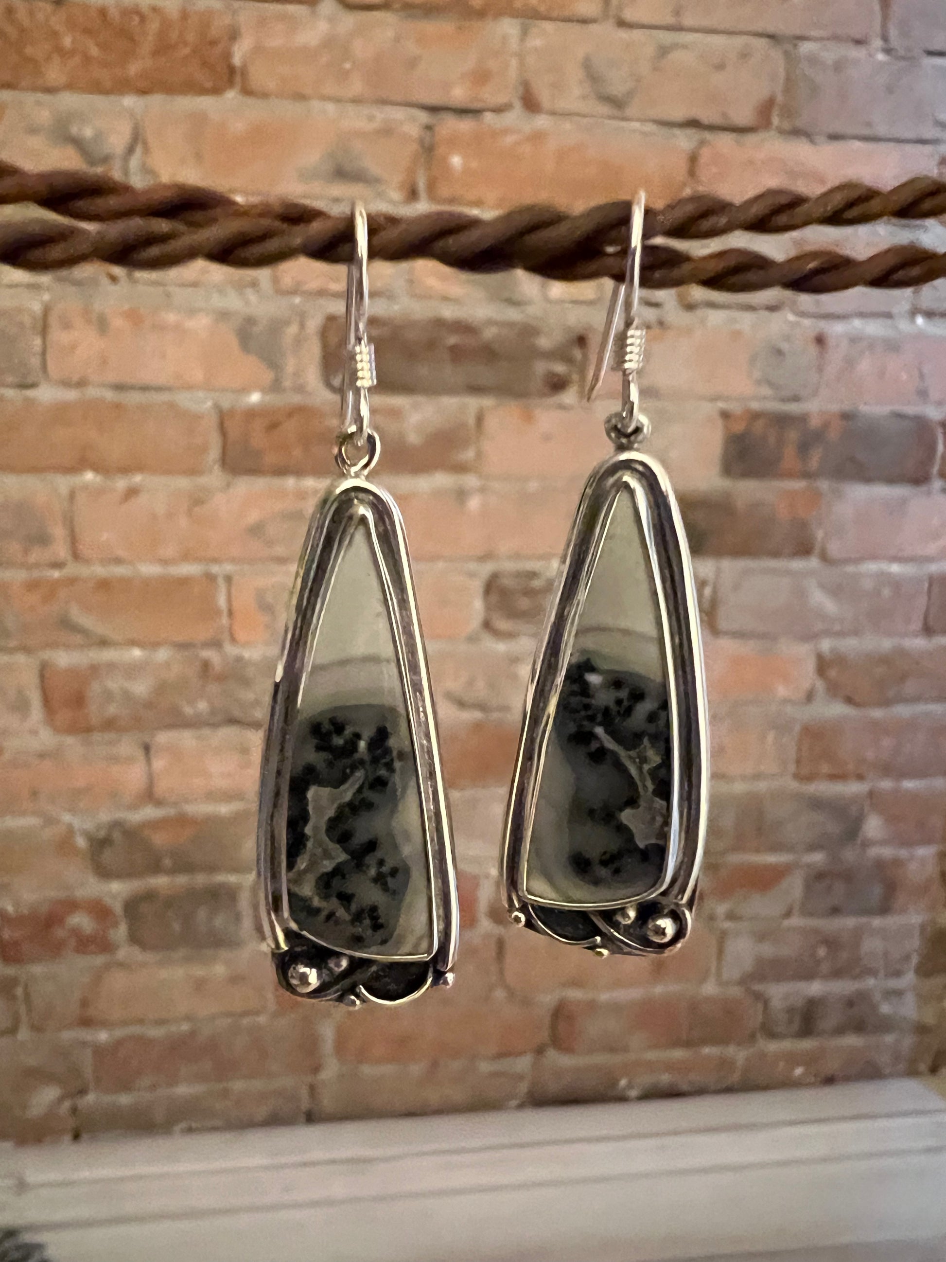 One-Of-A-Kind Artisanal Earrings – detail shot of handcrafted sterling silver one-of-a-kind artisanal earrings showing texture and gemstone, black background