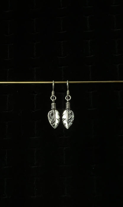Petite Feather Earrings – pair of handcrafted sterling silver small oxidized feather drop earrings with detailed quill and barb texture on french hooks, black background