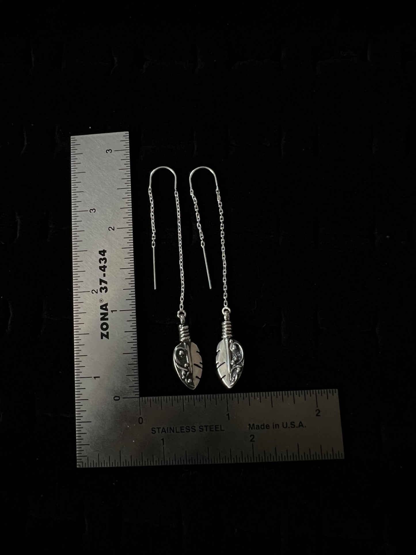 Petite Feather Threaders – size reference showing sterling silver petite feather threader earrings approximately 2 inches long next to ruler, black background