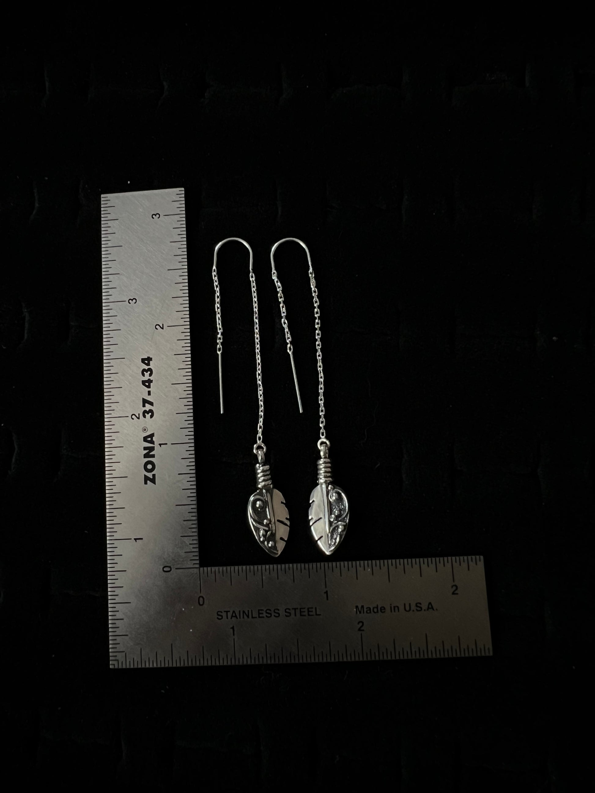 Petite Feather Threaders – size reference showing sterling silver petite feather threader earrings approximately 2 inches long next to ruler, black background