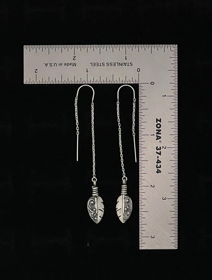 Petite Feather Threaders – lifestyle shot of handcrafted sterling silver petite feather threader earrings worn on ear, black background