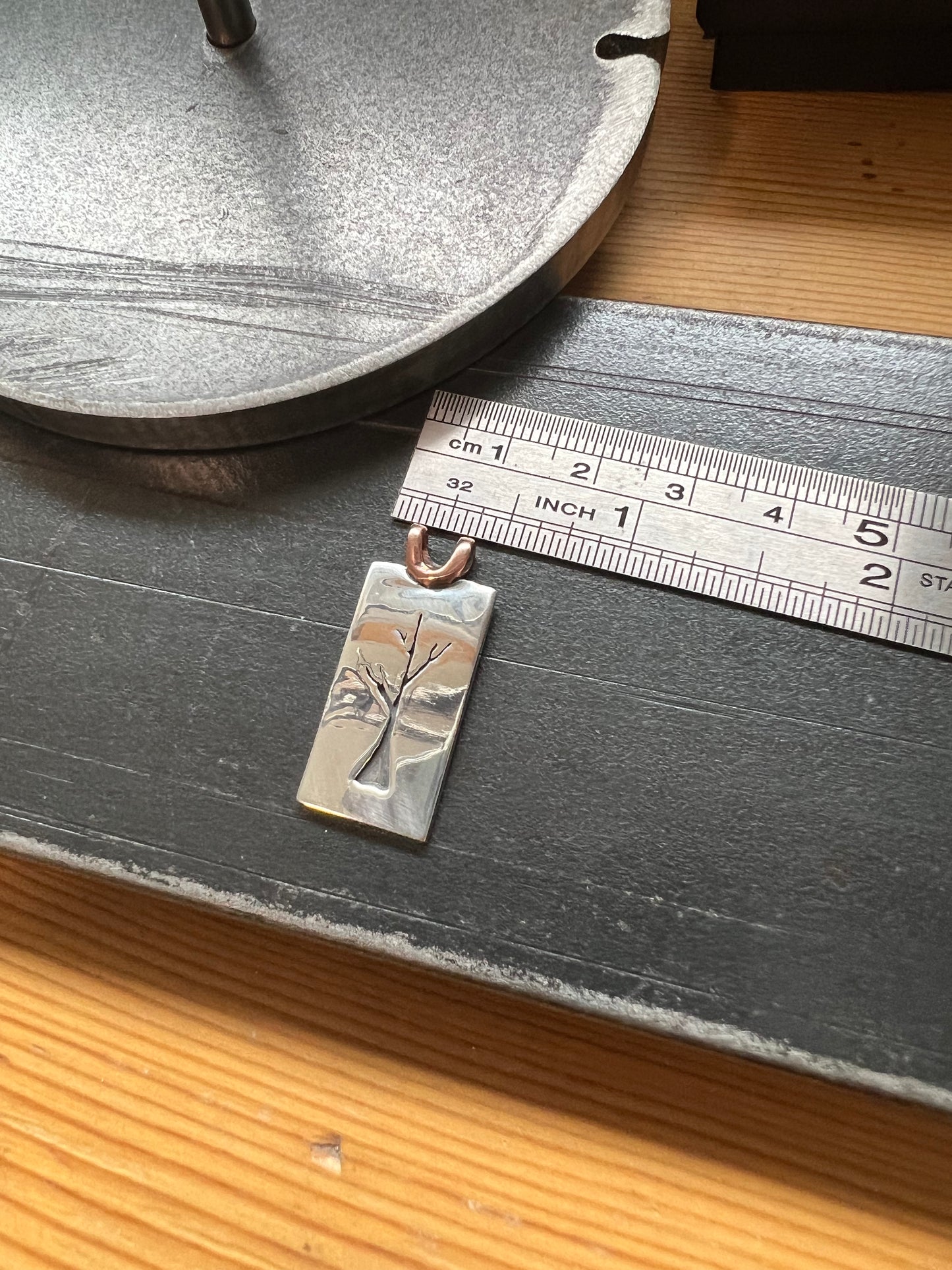 Sapling Tree Pendant one-of-a-kind – size reference showing handcrafted sterling silver sapling tree pendant approximately 1 inch tall next to ruler, black background