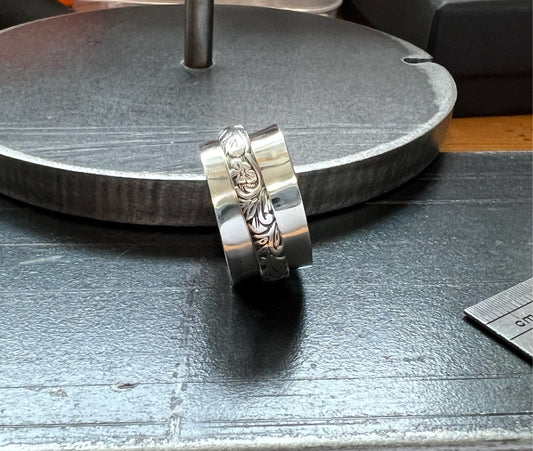 Spinner Ring – close-up of sterling silver spinner ring showing textured rotating outer band detail, black background