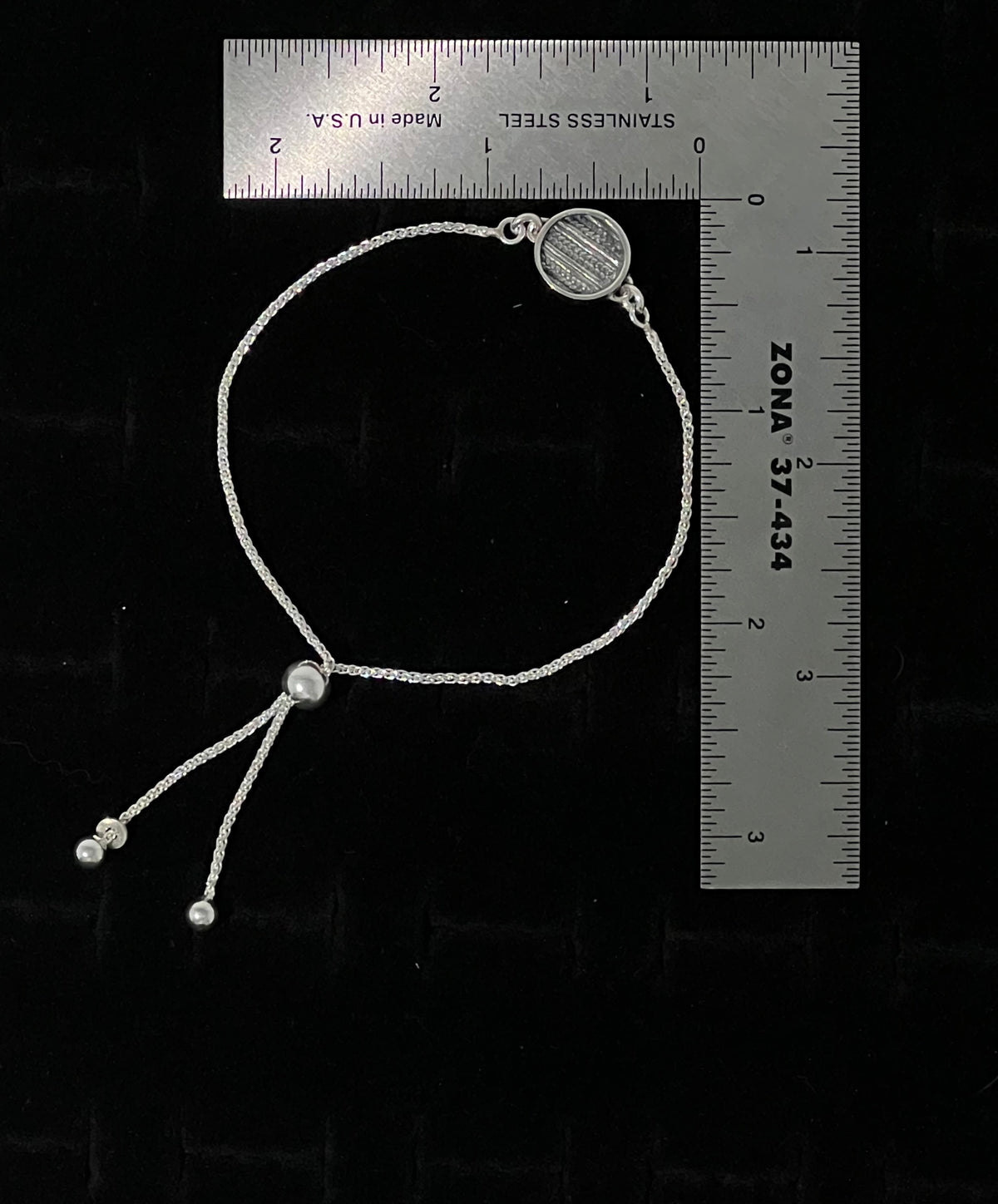 Sterling Silver Adjustable Sweater Bracelet – size reference showing sterling silver knit-texture disc bracelet approximately 7 inches long next to ruler, black background