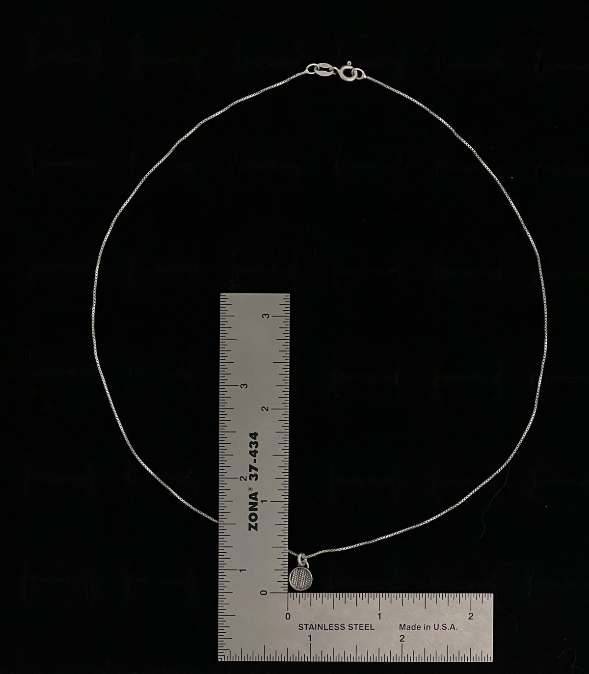 Sweater Charm Necklace – size reference showing sterling silver knit-texture disc charm necklace approximately 18 inches long next to ruler, black background