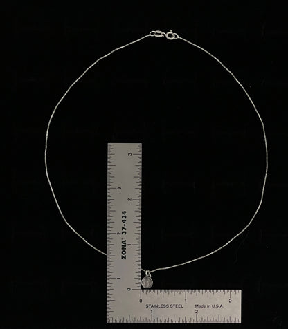 Sweater Charm Necklace – size reference showing sterling silver knit-texture disc charm necklace approximately 18 inches long next to ruler, black background