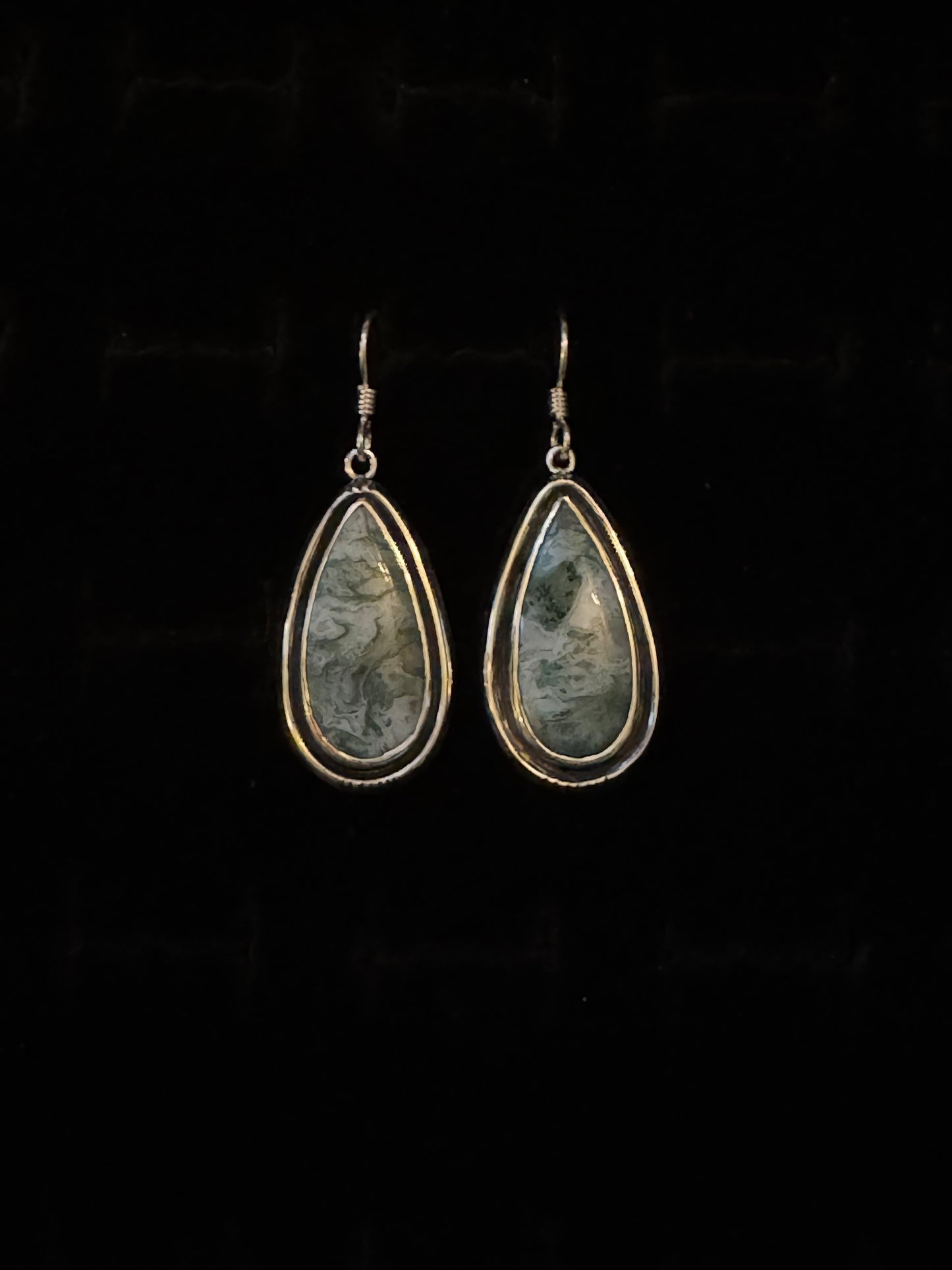 A pair of Teal Moss Agate earrings with a teardrop shape, mounted on Sterling Silver hooks.