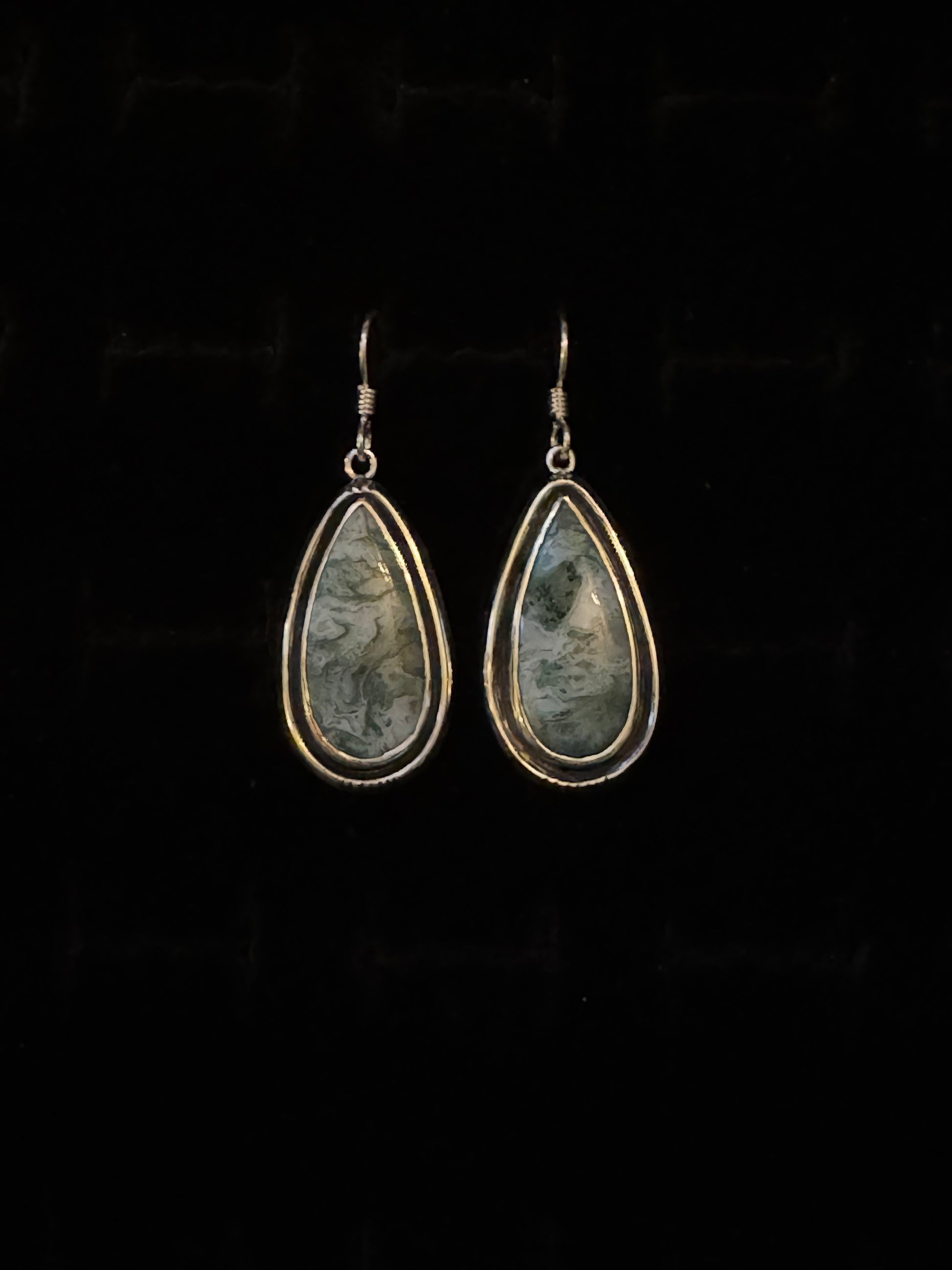 A pair of Teal Moss Agate earrings with a teardrop shape, mounted on Sterling Silver hooks.