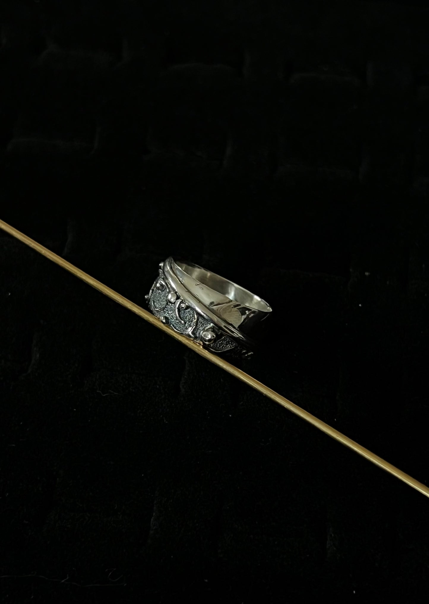 Wide Feather Ring – lifestyle shot of handcrafted sterling silver wide oxidized feather band ring worn on finger outdoors