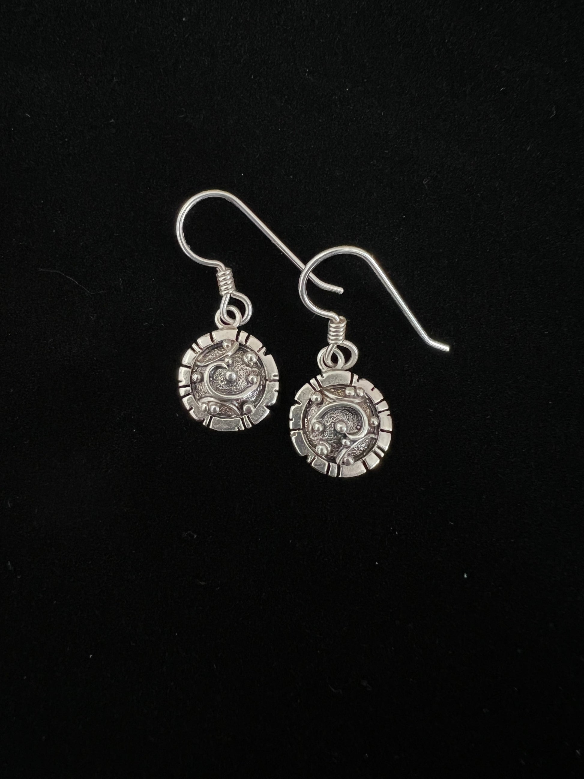 Artisanal Elements Earrings – overhead view of sterling silver artisanal elements drop earrings showing mixed-metal texture detail, black background
