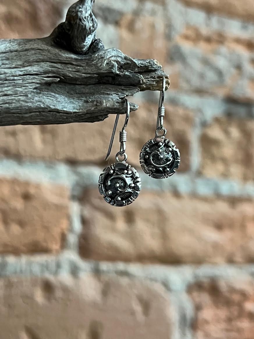 Artisanal Elements Earrings – close-up of sterling silver artisanal elements disc drop earrings showing texture detail, natural light