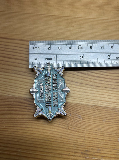 Colorado High-Grade Silver Studios enamel pin – vertical size reference showing light blue art deco starburst pin approximately 2.5 inches tall next to ruler, wooden surface