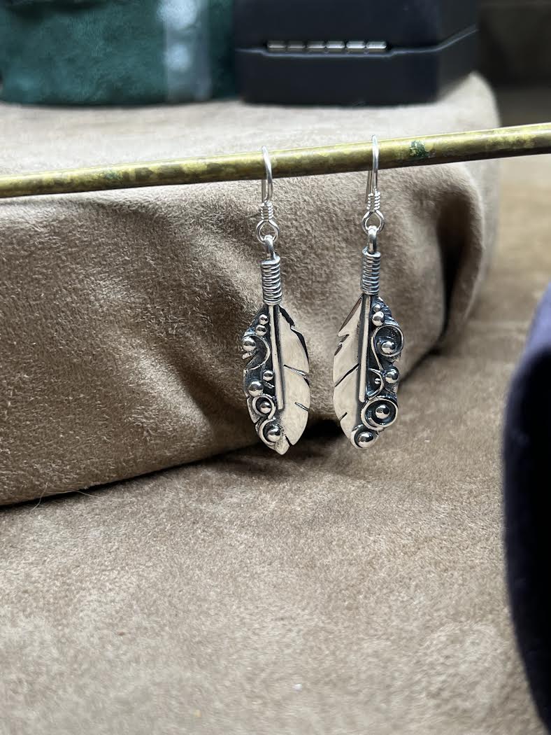 Long Feather Earrings – detail shot of handcrafted sterling silver long oxidized feather drop earrings showing fine barb texture, black background