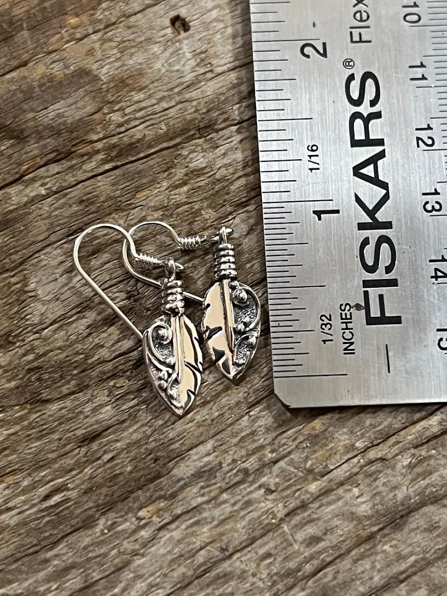Petite Feather Earrings – size reference showing sterling silver petite feather drop earrings approximately 1.5 inches long next to ruler, black background