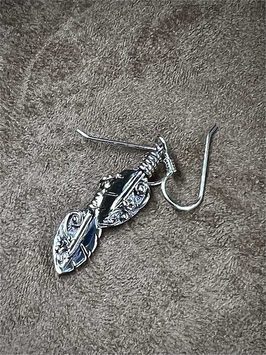Petite Feather Earrings – side view of sterling silver small oxidized feather drop earrings showing quill depth detail, black background